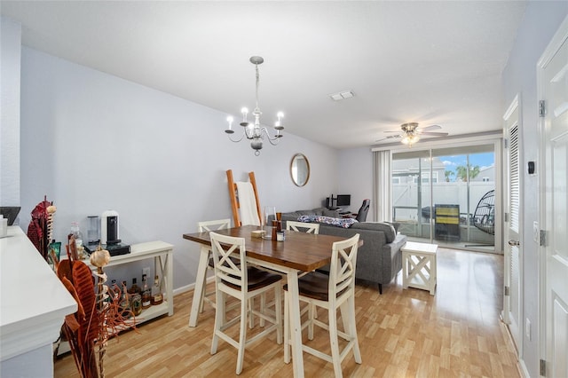 dining area featuring visible vents, light wood-style floors, and ceiling fan with notable chandelier