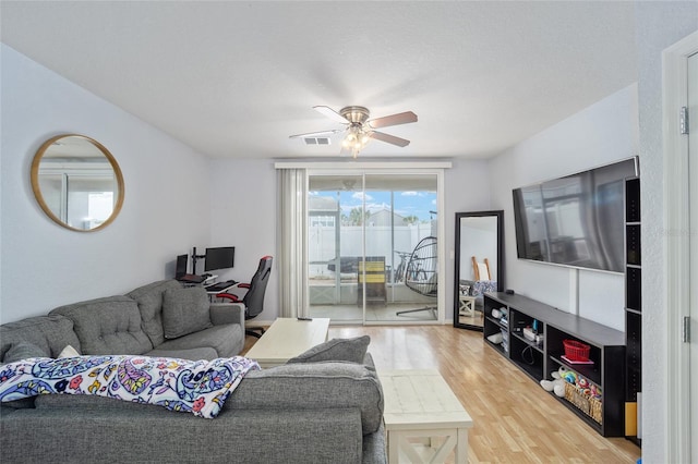 living area featuring visible vents, wood finished floors, and a ceiling fan