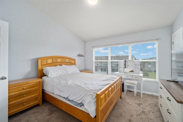bedroom featuring light colored carpet and lofted ceiling