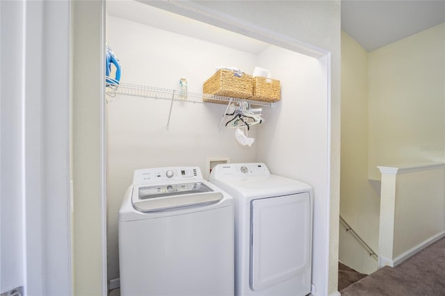 clothes washing area featuring carpet flooring, baseboards, washer and dryer, and laundry area