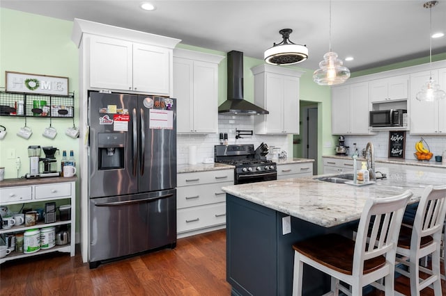 kitchen featuring pendant lighting, white cabinets, dark wood-type flooring, black appliances, and wall chimney exhaust hood