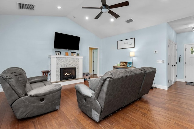 living room featuring lofted ceiling, ceiling fan, dark hardwood / wood-style flooring, and a fireplace