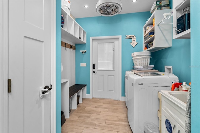 laundry room with washing machine and dryer and light wood-type flooring