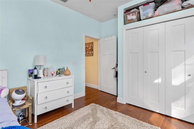 bedroom with a closet and dark hardwood / wood-style flooring