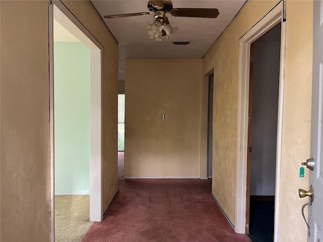 hall with dark colored carpet