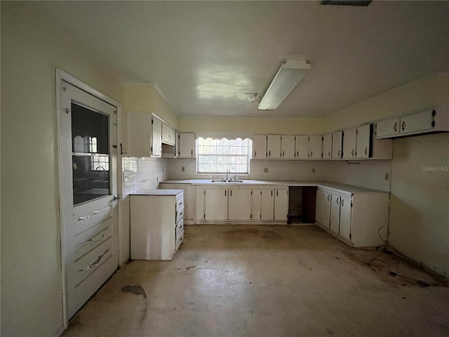 kitchen featuring tasteful backsplash, white cabinets, and sink