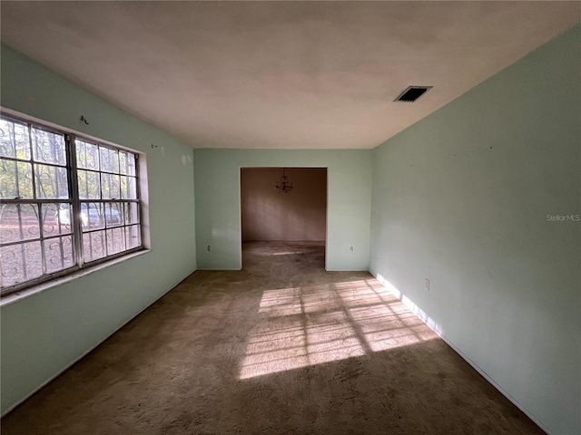 unfurnished room with an inviting chandelier and light carpet