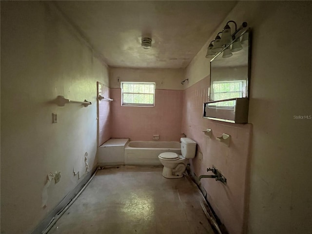 bathroom with toilet, shower / bathtub combination, and concrete flooring