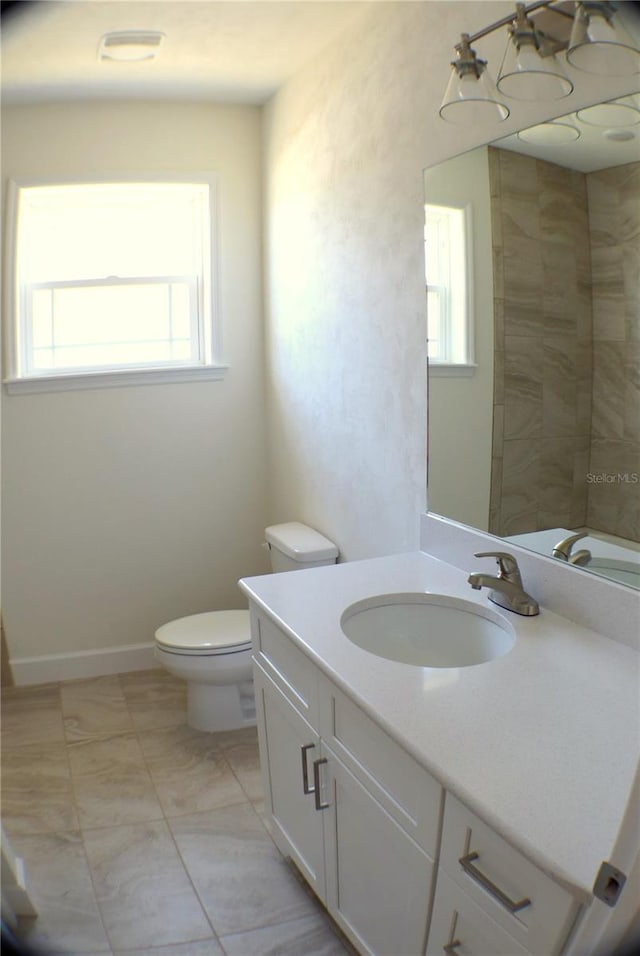 bathroom with vanity, toilet, and a wealth of natural light