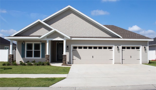 craftsman house featuring a front yard and a garage