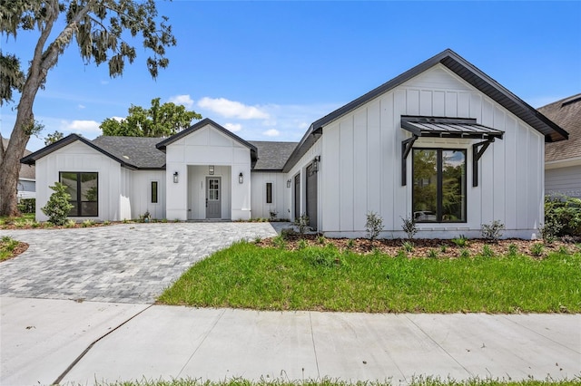 modern inspired farmhouse with a front lawn