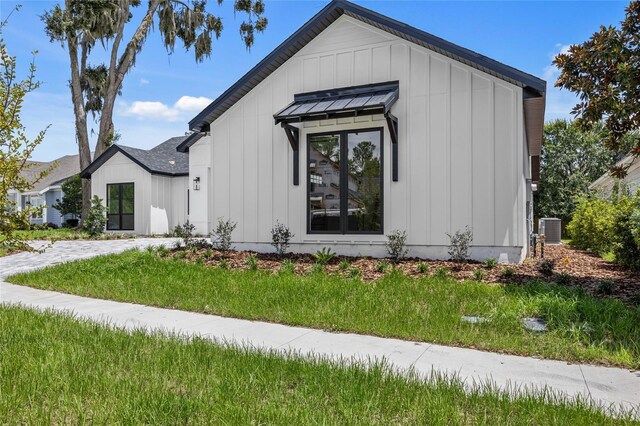 view of front of home featuring a front yard and central AC unit