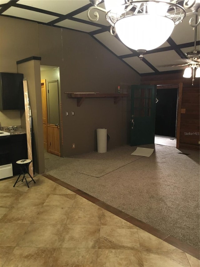 basement featuring ceiling fan with notable chandelier and tile floors