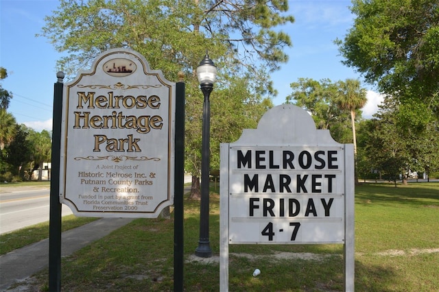 community / neighborhood sign featuring a yard