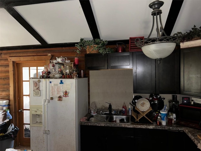 kitchen with white refrigerator, stone counters, beamed ceiling, and sink