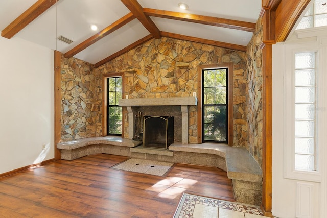 unfurnished living room featuring a stone fireplace, wood-type flooring, and a healthy amount of sunlight