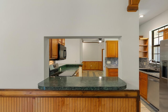 kitchen with light tile patterned floors, stainless steel appliances, sink, kitchen peninsula, and ceiling fan