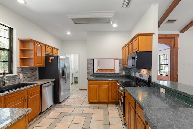 kitchen featuring decorative backsplash, stainless steel appliances, sink, and a healthy amount of sunlight