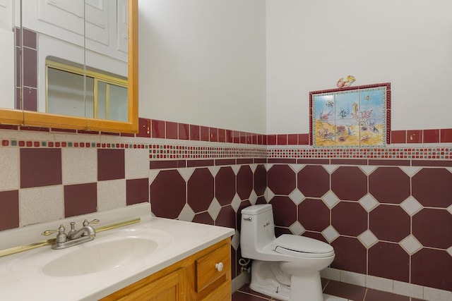 bathroom with tile patterned floors, tile walls, toilet, and vanity