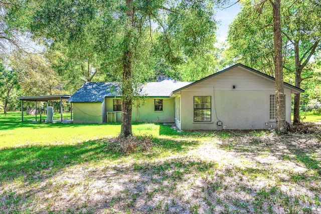 rear view of property featuring a yard and central AC