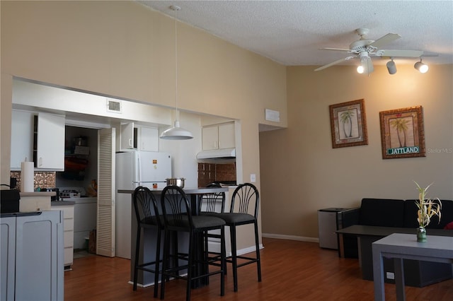 kitchen featuring dark wood-type flooring, ceiling fan, and white cabinets