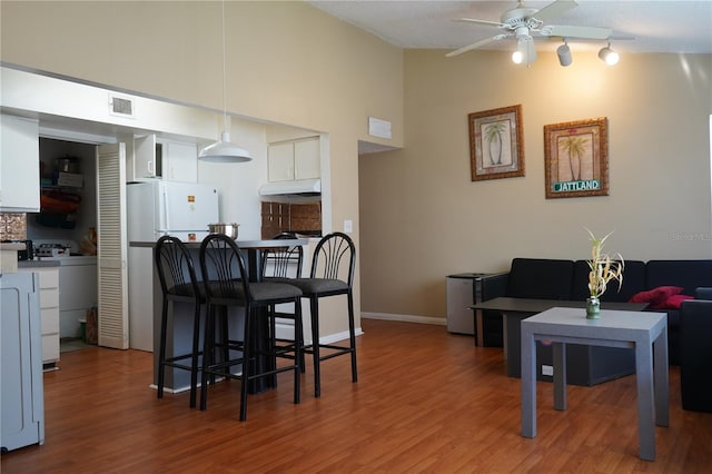 kitchen with white cabinets, ceiling fan, wood-type flooring, and tasteful backsplash