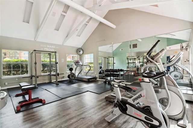 gym with dark hardwood / wood-style flooring and high vaulted ceiling