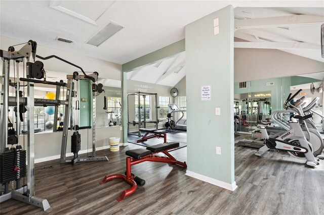 workout area with lofted ceiling and hardwood / wood-style floors