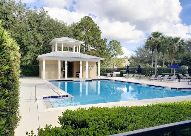 view of swimming pool featuring a patio and an outdoor structure