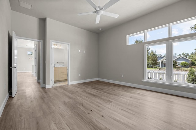 unfurnished bedroom with connected bathroom, ceiling fan, light hardwood / wood-style flooring, and multiple windows