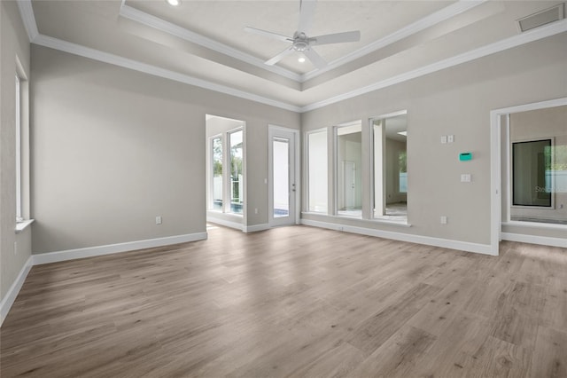 interior space with a tray ceiling, light hardwood / wood-style flooring, and ceiling fan