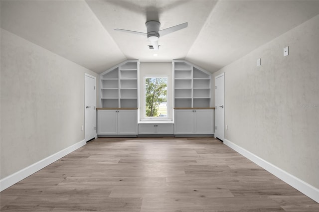 additional living space featuring ceiling fan, light hardwood / wood-style floors, built in features, and vaulted ceiling