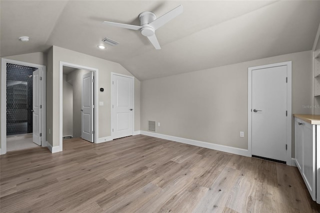 additional living space with ceiling fan, light hardwood / wood-style floors, and vaulted ceiling