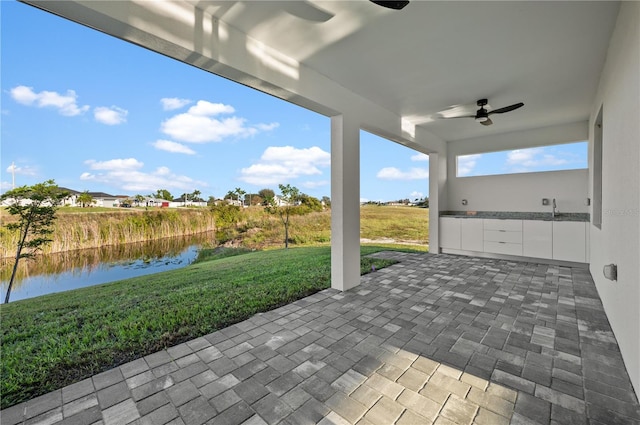 view of patio / terrace with a water view and ceiling fan