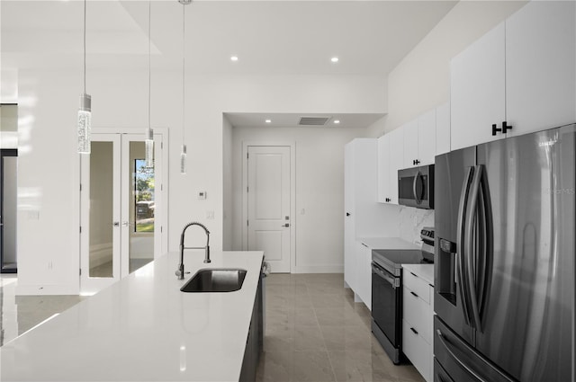 kitchen featuring stainless steel appliances, tile floors, white cabinets, sink, and pendant lighting