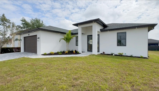 view of front of property with a front lawn and a garage