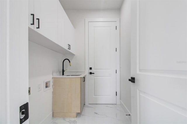 laundry area featuring light tile flooring, washer hookup, cabinets, and sink