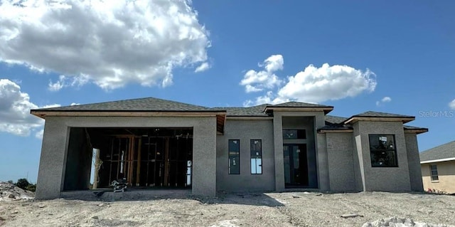 view of front facade with a garage and stucco siding