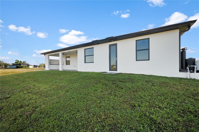 rear view of house featuring a yard