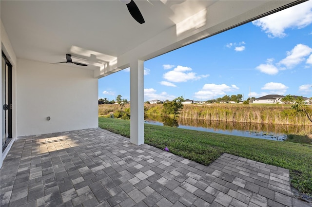 view of terrace with ceiling fan and a water view