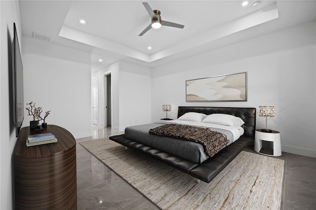 bedroom featuring ceiling fan, a tray ceiling, and tile floors