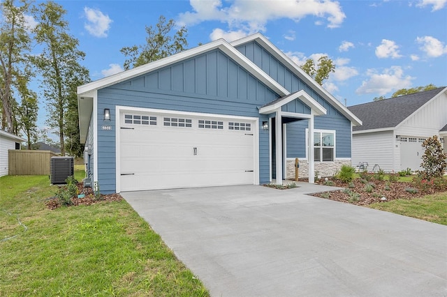 view of front of home with a front yard, a garage, and central air condition unit