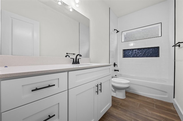 full bathroom featuring wood-type flooring, vanity, toilet, and washtub / shower combination