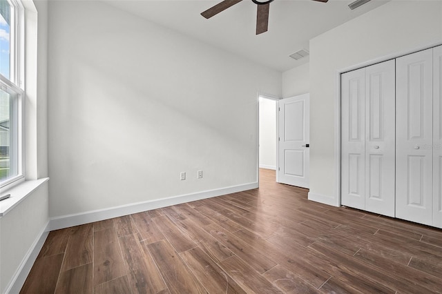 unfurnished bedroom featuring a closet, ceiling fan, and dark hardwood / wood-style flooring