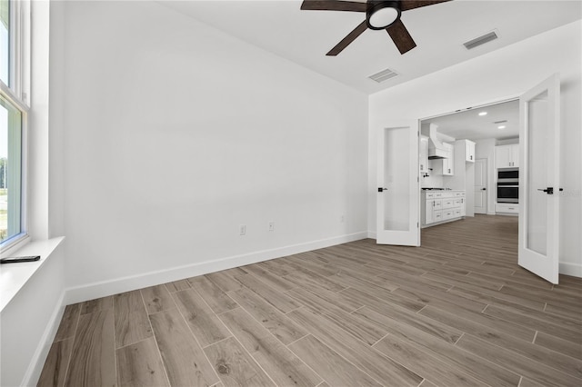 empty room with light wood-type flooring and ceiling fan