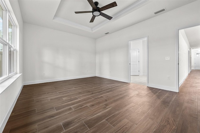 unfurnished room with ceiling fan, ornamental molding, a tray ceiling, and dark hardwood / wood-style flooring