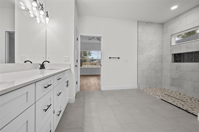 bathroom with a tile shower, vanity, hardwood / wood-style floors, and plenty of natural light