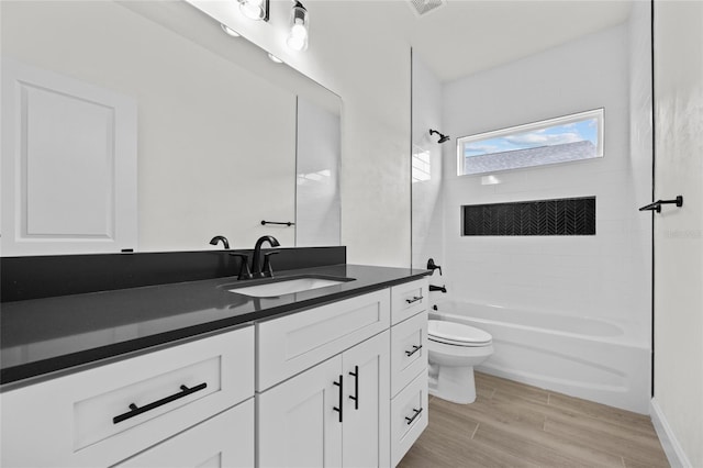 full bathroom with vanity, toilet, and tiled shower / bath