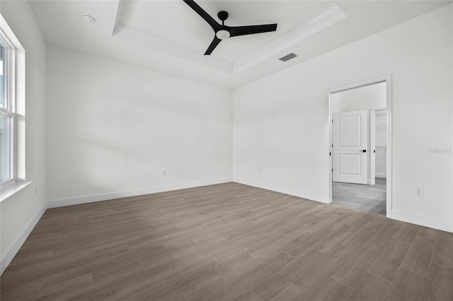 spare room with wood-type flooring, a tray ceiling, and ceiling fan