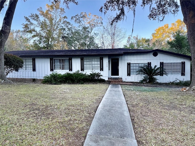 single story home featuring a front lawn